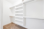 Fantastic walk in closet with built in shelving.