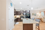 Kitchen with pantry and a flat bar with seating.