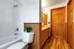 Full bath with tub surround + wainscoting on wall