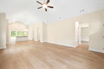Great room with vaulted ceiling and lighted fan.