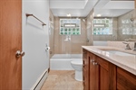 Renovated bathroom featuring travertine tile