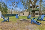 Large yard with firepit and storage shed.
