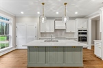 The kitchen features a flat bar painted island.