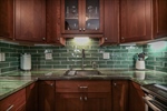 Tile backsplash compliments the cherry cabinets