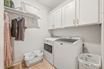 Fully enclosed laundry room with cabinetry.