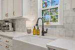Farmhouse sink and full tile backsplash.