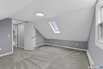 Upper level primary bedroom with skylight