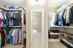 Large walk in closet with built in shelving.