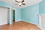 Primary bedroom with lighted ceiling fan.