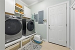 Updated laundry room with cabinetry.