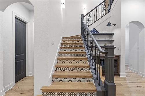 Sweeping staircase with Italian tile risers