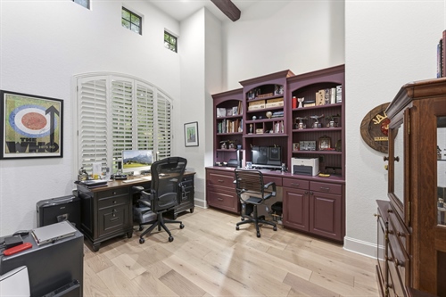 Executive study with rich wood beams and builtins