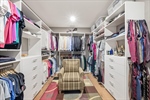 Walk in closet with newly installed closet system.