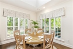 Cheery dining room with plantation shutters.