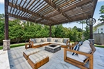 Shady pergola has fire pit and conversation space