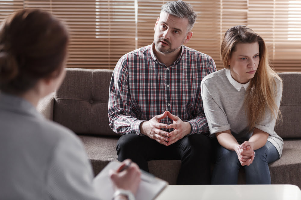 depressed woman and husband talking with therapist for couples