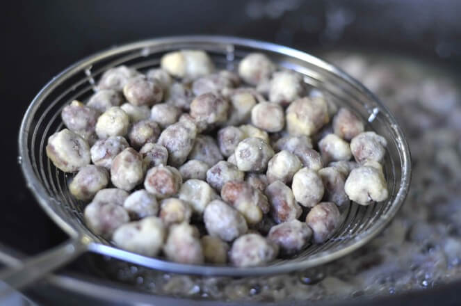 After the fried peanuts are drained, remove them and put them in a bowl