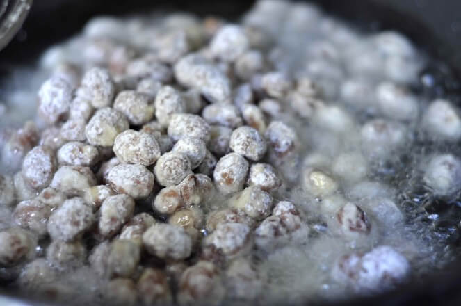 The fried red peanuts in the pan are slightly cracked, and the color is yellow.