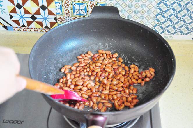 Peanuts are poured into the syrup