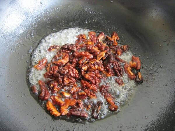 Pour in cooked walnuts and stir quickly with a wooden spatula