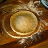 Pizza dough flattened into a circle.