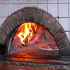 Pizza baking in the flames of the hearth fire.