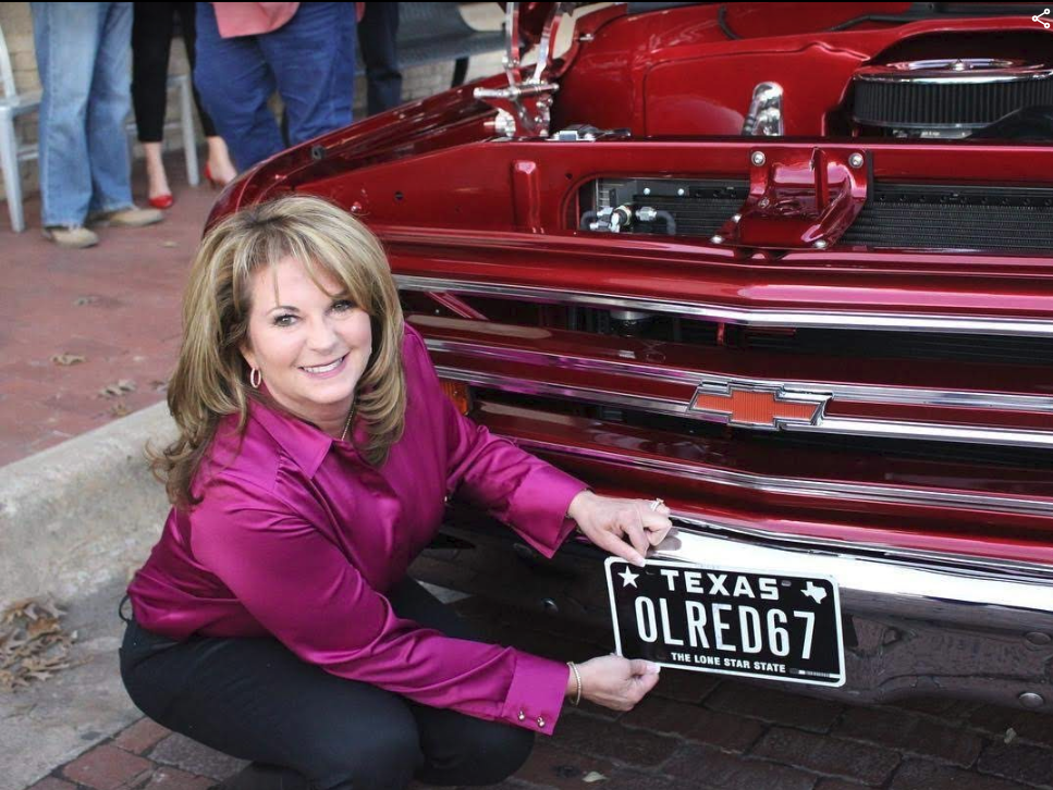 Heather Perry holds the new plates to her father’s restored 1967 Chevy C10, frisco, downtown plano