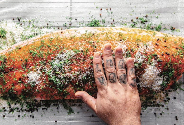 Chef "rubbing" seasonings on a fish fillet