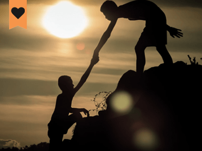 image of one person helping another person climb up a hill