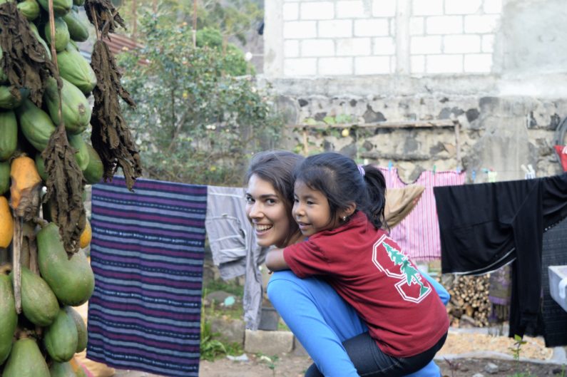 First-year medical student Tori Bawel plans a career improving health in areas of poverty. Fátima shows off her Stanford gear as she gets a ride from Bawel. Because of contributions from FSI, children like Fátima are getting the nutritional supplements they need.