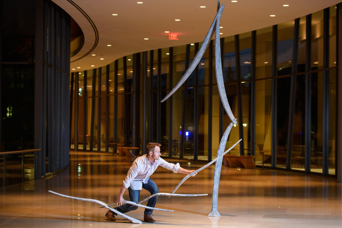 Sculptor Will Clift adjusts the placement of his sculpture before a rehearsal at the Bing Concert Hall.