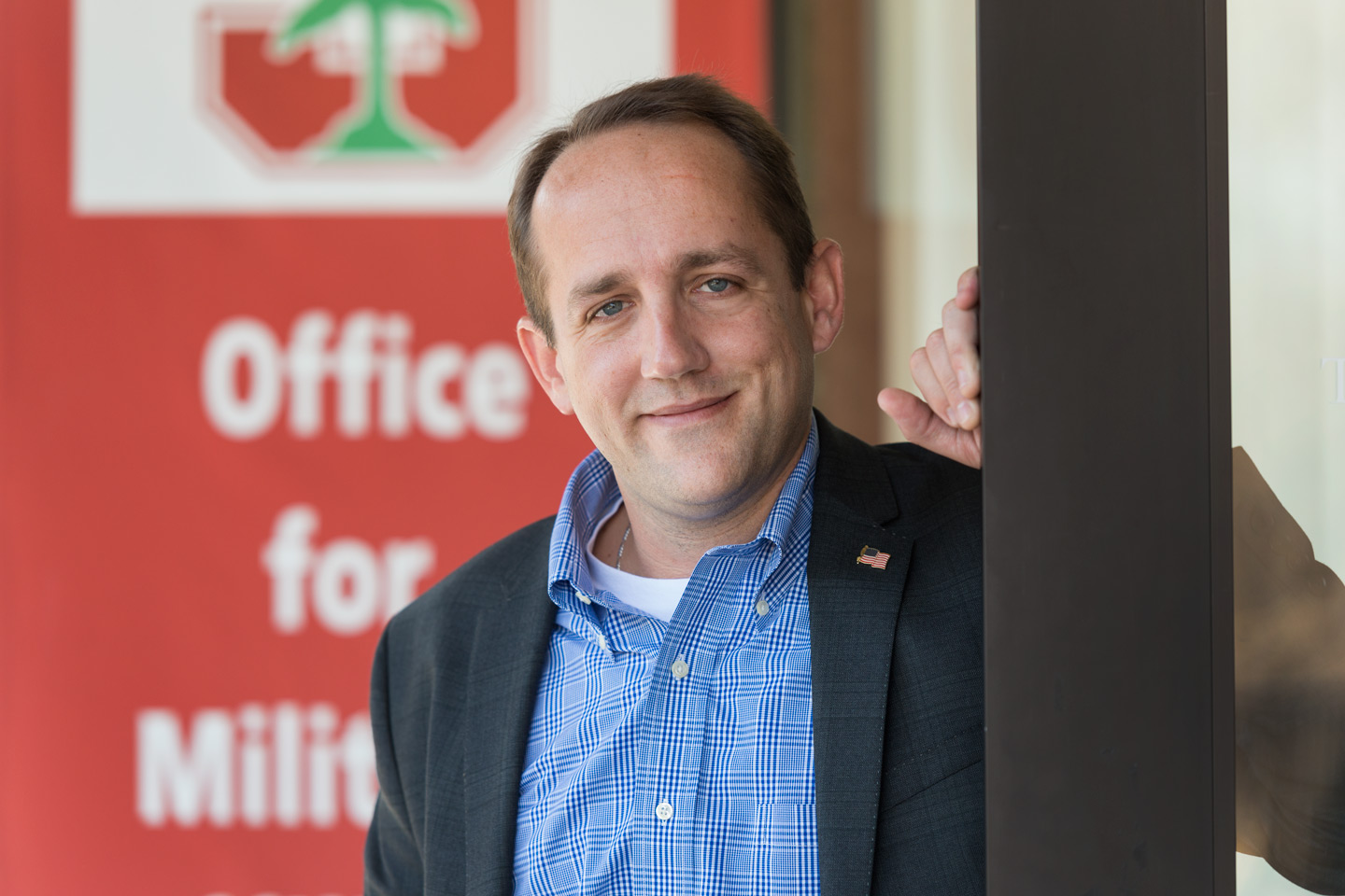 Dustin Noll, specialist in the Office for Military-Affiliated Communities, standing outside his office