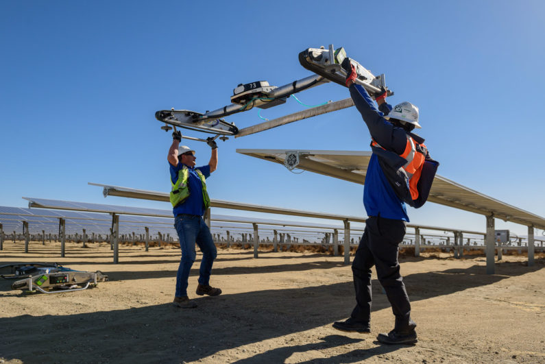 Workers cleaning solar panels