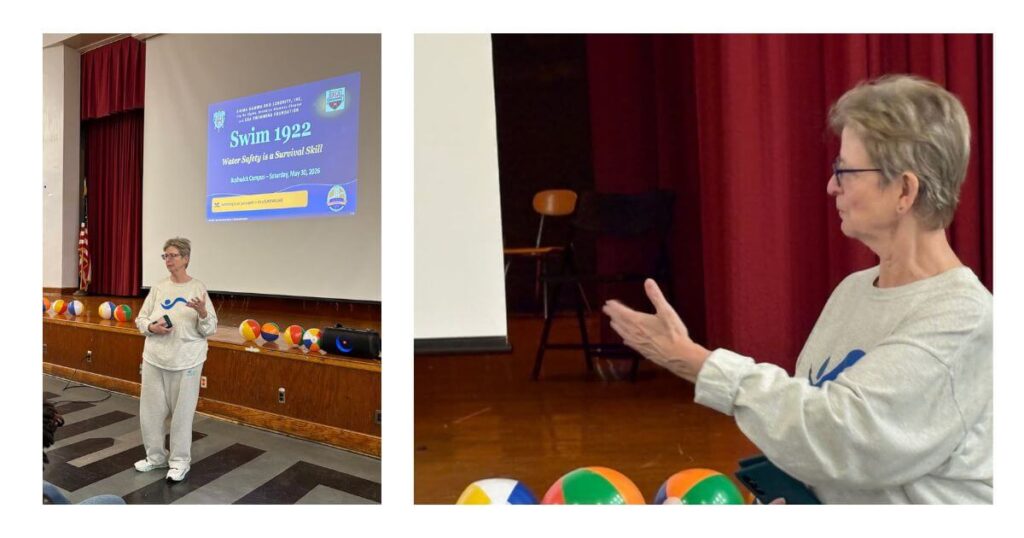 Swim Strong Foundation Executive Director Shawn Slevin delivers a water safety presentation to families at Bushwick Campus during WaterPalooza 26, with the Swim 1922 program slide projected behind her and colorful beach balls lining the stage.