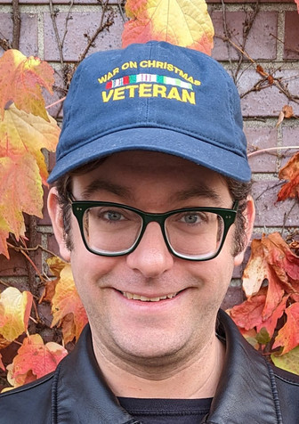 Alex wearing a "War on Christmas Veteran" baseball cap.