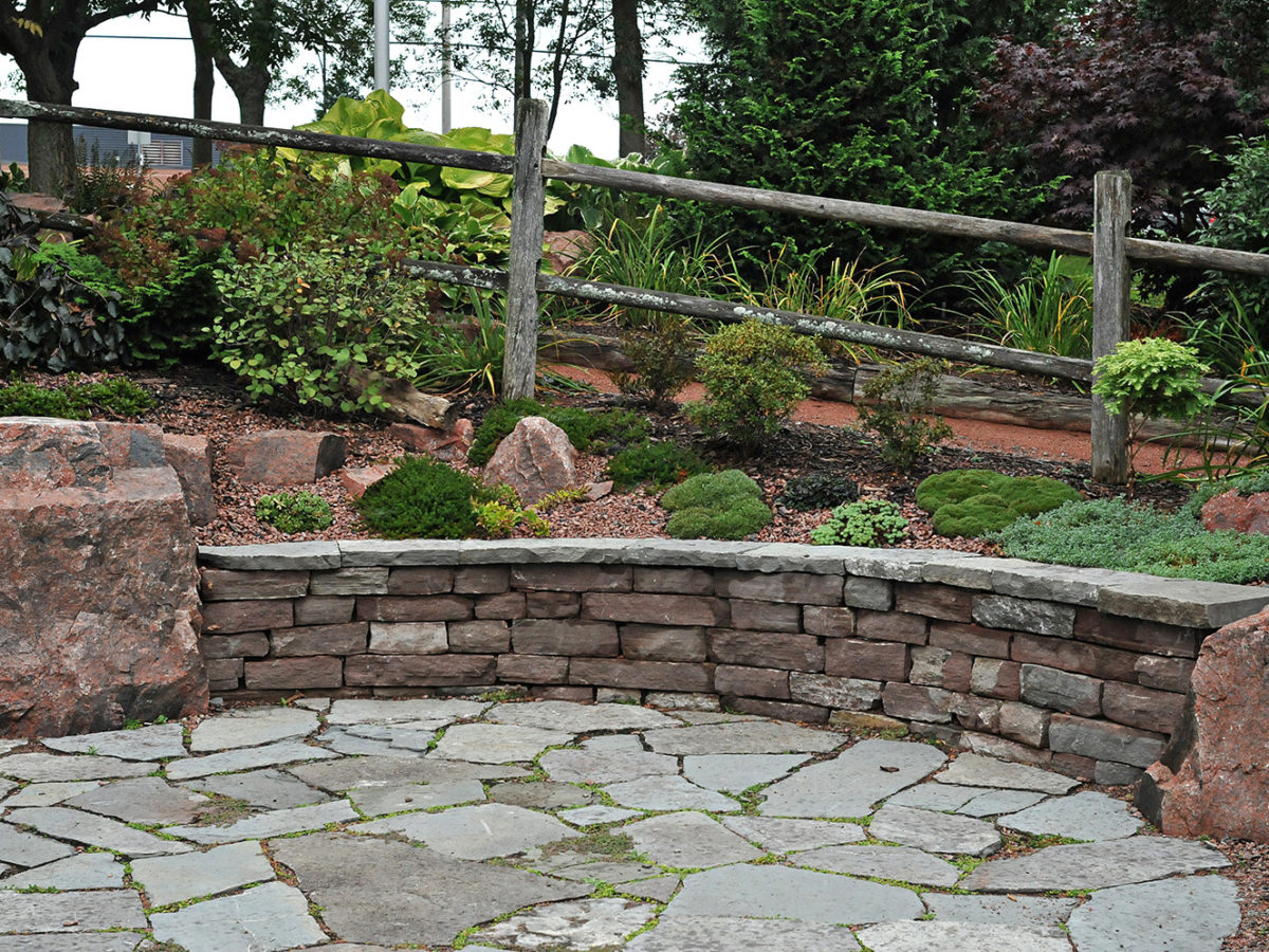 flagstone patio with rock wall and garden