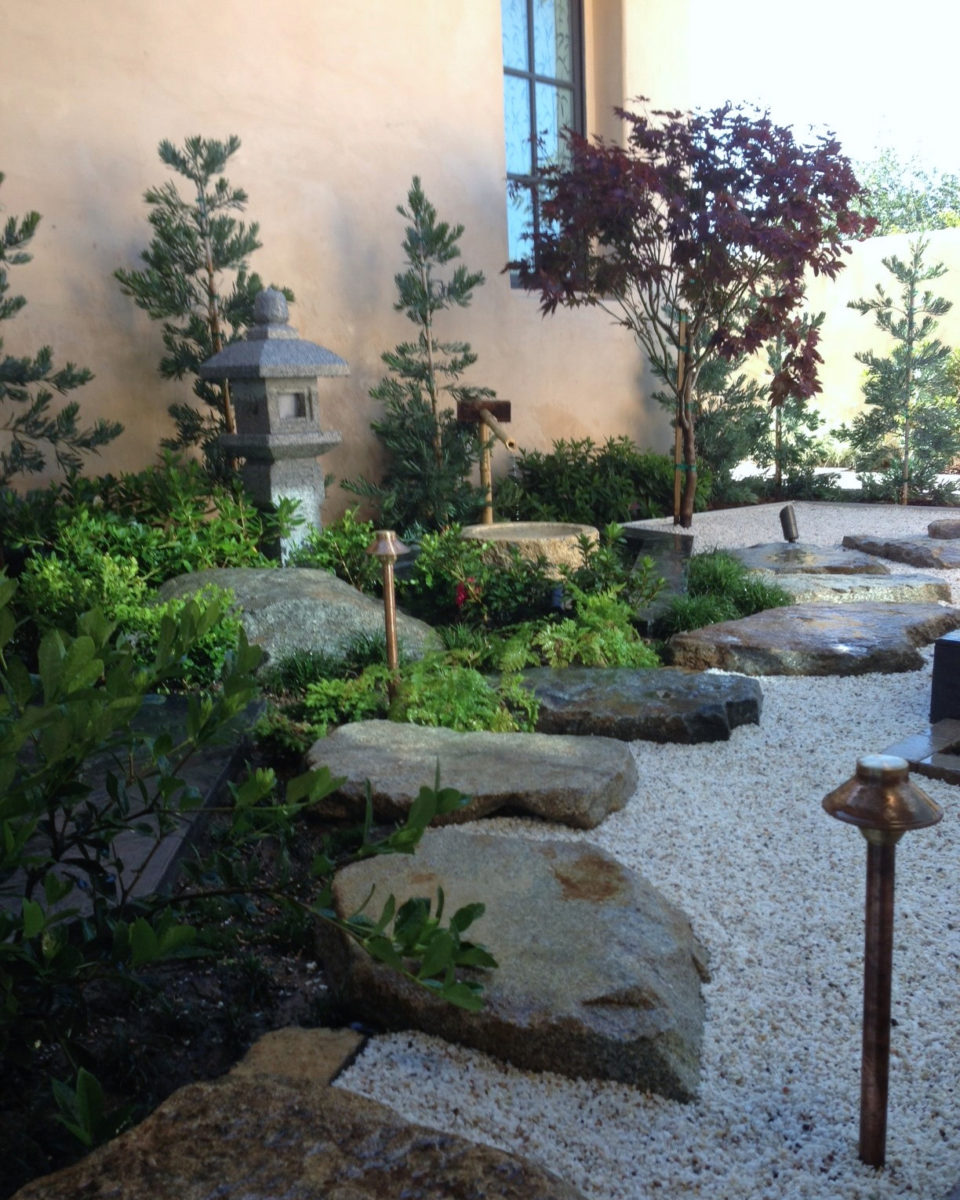 Backyard zen garden pathway with stepping stones and boulders