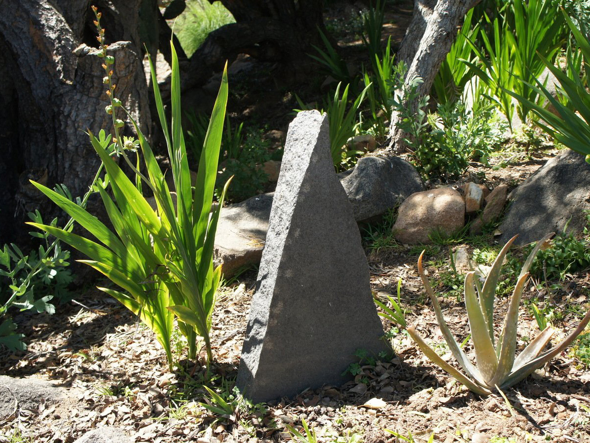 Carved stone piece in mosaic rock garden