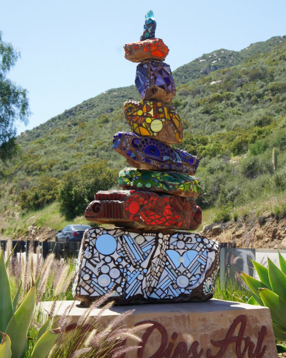 Stacked mosaic rock art piece in yard