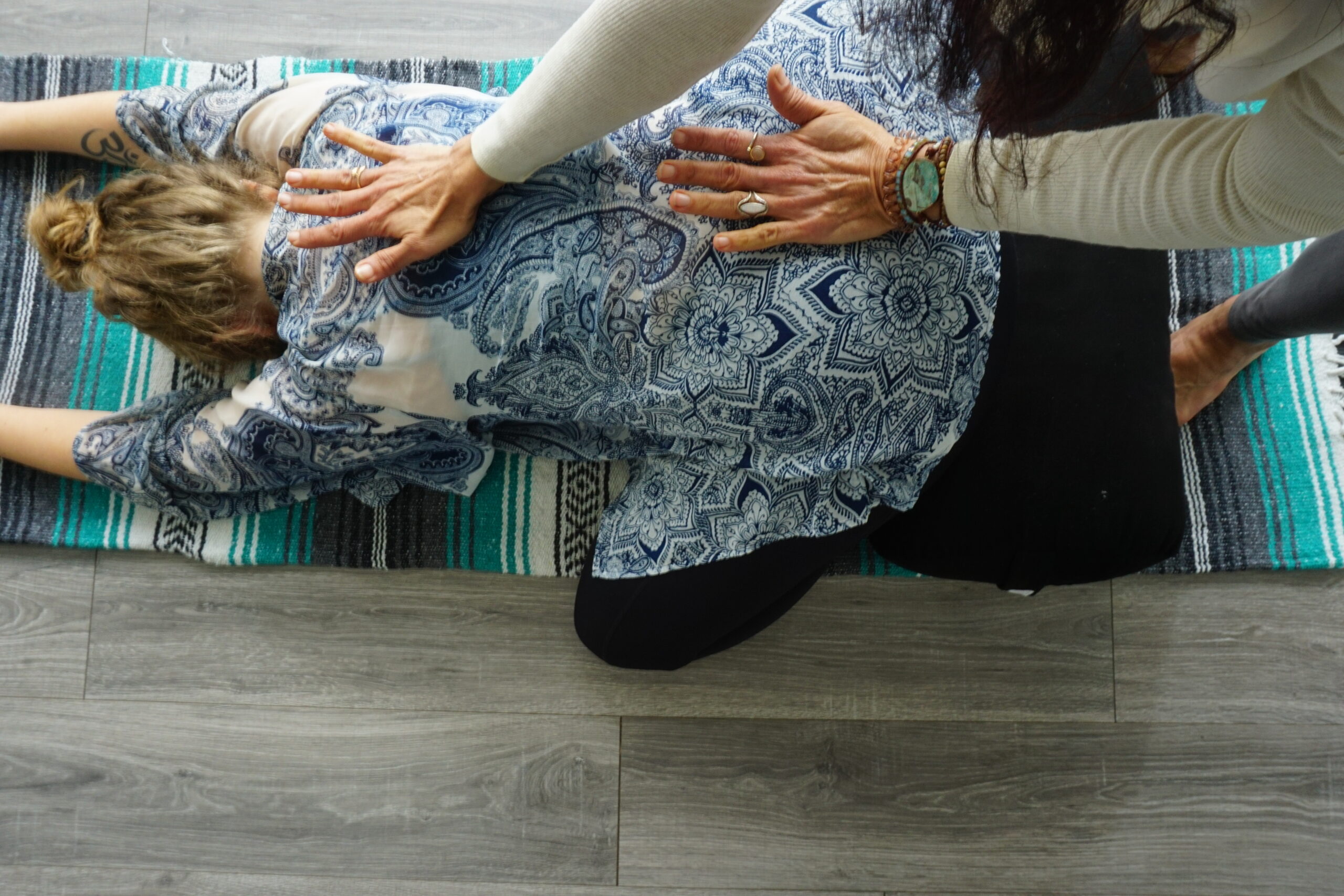 Aria Morgan adjusting student. photo by Montoya Miller for Sojourn Yoga adjustment child pose
